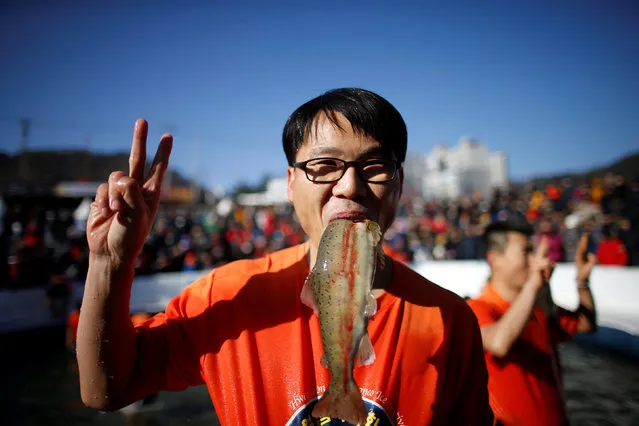 A man reacts after catching a trout with his hands during an event promoting the Ice Festival on a frozen river in Hwacheon, south of the demilitarized zone (DMZ) separating the two Koreas, January 14, 2017. (Photo by Kim Hong-Ji/Reuters)