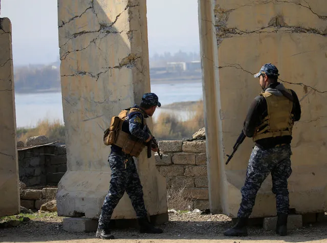 Iraqi Federal police take cover near the Tigris river during a battle with Islamic State militants in the district of Yarimja in southern Mosul, Iraq, January 14, 2017. (Photo by Ahmed Saad/Reuters)