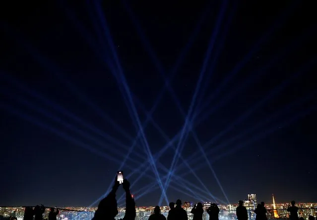 Visitors watch the “Sparkling Light Tree”, a light show to celebrate Christmas, at the Shibuya Sky observation deck in Tokyo, Japan on December 7, 2023. (Photo by Kim Kyung-Hoon/Reuters)