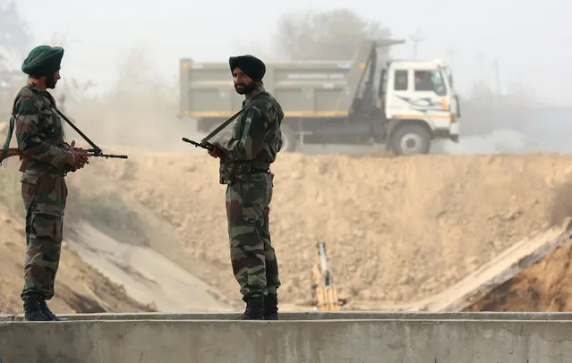 Armed policemen stand guard at the partially damaged Munak canal, that supplies three-fifths of the water to Delhi, in Sonipat in the northern state of Haryana, India, February 24, 2016. A political ally of Prime Minister Narendra Modi was shouted down on Tuesday by a crowd angered by rioting in Haryana that destroyed businesses, paralysed transport and cut water supplies to metropolitan Delhi. The army on Monday retook control of the canal. (Photo by Cathal McNaughton/Reuters)