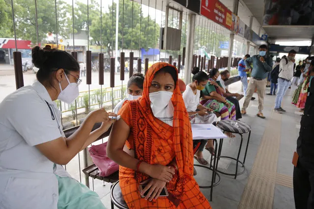 A health worker administers the vaccine for COVID-19 during a special vaccination drive by the municipal corporation at a bus stand in Ahmedabad, India, Friday, September 17, 2021. (Photo by Ajit Solanki/AP Photo)