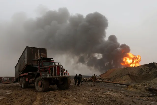 Fiirefighters put out a fire at oil wells, which were set ablaze by Islamic State militants before they fled the oil-producing region of Qayyara, Iraq, January 28, 2017. (Photo by Muhammad Hamed/Reuters)