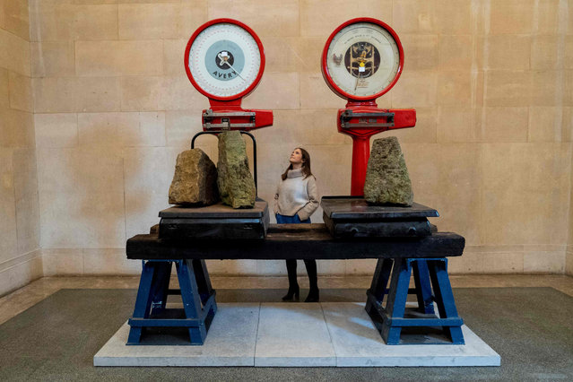 Gallery assistants pose for a photograph with items forming an installation entitled “The Asset Strippers” by British artist Mike Nelson, during a photocall at Tate Britain in London on March 18, 2019, ahead of the opening of his exhibition which forms the Tate Britain Commission 2019. The annual Tate Britain Commission invites artists to make a work in response to the unique architecture and history of the neo-classical Duveen Galleries at the heart of Tate Britain. (Photo by Niklas Halle/AFP Photo)