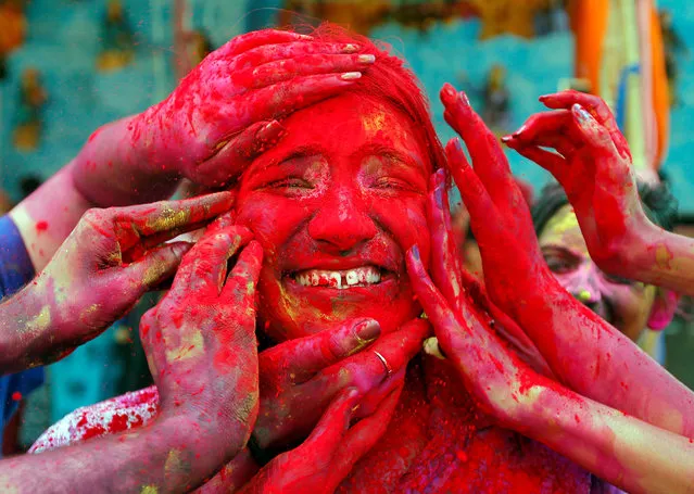A woman reacts as devotees apply coloured powder on her face during celebrations for Holi outside a temple on the outskirts of Kolkata, India, March 21, 2019. (Photo by Rupak De Chowdhuri/Reuters)