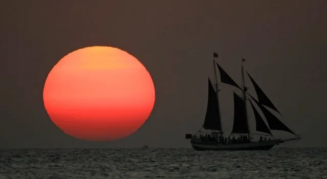 A sailboat is silhouetted against the setting sun Friday, January 6, 2017, off the coast of Key West, Fla. (Photo by Charlie Riedel/AP Photo)