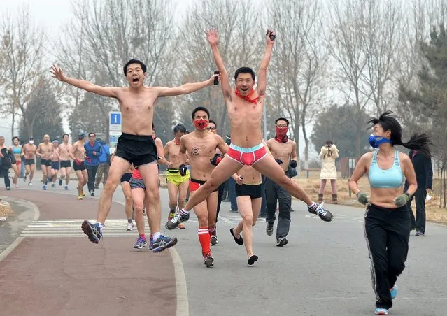 This picture taken on February 23, 2014 shows participants jumping and running as they take part in the annual 3.5 km Undie Run held in the Olympic Forest Park smog-covered Beijing. (Photo by AFP Photo/STR)