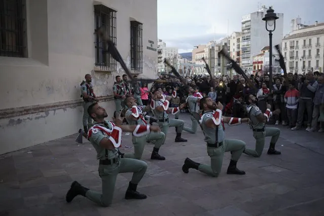 Spanish legionnaires throw their weapons in the air during a performance outside the church of Mena brotherhood during Holy Week in Malaga, southern Spain, March 22, 2016. (Photo by Jon Nazca/Reuters)