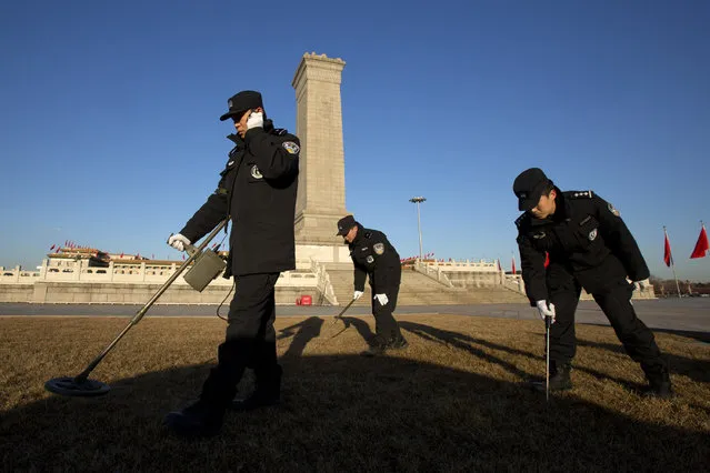 Policemen check for explosives on Tiananmen Square before the opening session of the annual National People's Congress held at the nearby Great Hall of the People in Beijing, China, Wednesday, March 5, 2014. (Photo by Alexander F. Yuan/AP Photo)