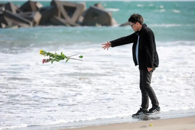A man offers a flower bouquet at a beach for his friend who lost his life by the tsunami on the 13th anniversary of the Great East Japan Earthquake on March 11, 2024 in Sendai, Miyagi, Japan. Japan observe the 13th anniversary of the 2011 Great East Japan earthquake, tsunami and nuclear meltdowns in which almost 16,000 were killed and hundreds of thousands made homeless. (Photo by The Asahi Shimbun via Getty Images)