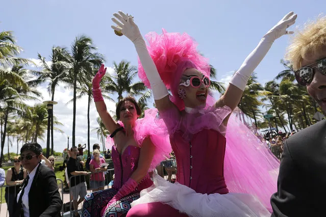 A performer named Adore, right, waves to the crowd during a parade along Ocean Drive at Miami Beach Gay Pride, Sunday, April 10, 2016, in Miami Beach, Fla. The annual event is meant to bring together members of the LGBT community, along with friends, families, and their supports. (Photo by Lynne Sladky/AP Photo)