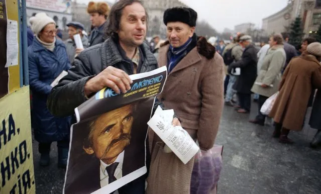 A supporter of Ukraine presidential candidate Levko Lukyanenko, a former political prisoner, carries campaign posters in Kiev on Saturday, November 30, 1991. The Ukraine presidential election and independence referendum on Sunday will be a key showdown in Soviet President Mikhail Gorbachev?s efforts to hold together the 12 remaining republics in a looser confederation. (Photo by Liu Heung Shing/AP Photo)