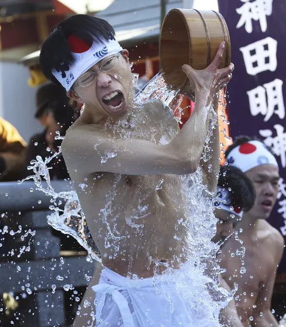A half-naked shrine parishioner using a wooden tub pours cold water onto himself during an annual cold-endurance festival at the Kanda Myojin Shinto shrine in Tokyo Saturday, January 11, 2014. Pouring cold water on their bodies is believed to purify their souls. (Photo by Koji Sasahara/AP Photo)