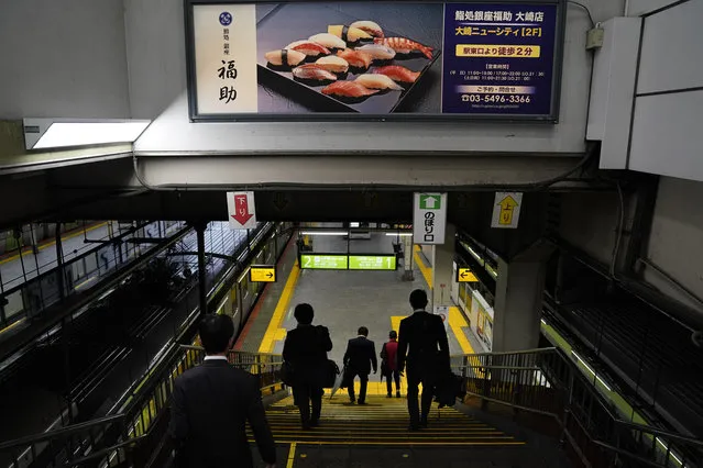 In this Tuesday, May 21, 2019, photo, a group of commuters wearing black suits walk down the steps to catch a Yamanote Line train at Osaki Station in Tokyo. For most Tokyoites, the line means an incredibly punctual and efficient transportation system for commuting. For tourists, it offers a glimpse into the life of ordinary people living in the city. (Photo by Jae C. Hong/AP Photo)