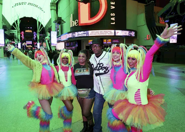 Derrick Westmorelandm of Houstonm and Alisha McCordm of Memphis, Tenn., pose with, from left, Melissa Dillon, Preeti Saha, Lydia Penn and Uli Auliani, all of Las Vegas, during the New Year's Eve party at the Fremont Street Experience in downtown Las Vegas on Friday, December 31, 2021. (Photo by K.M. Cannon/Las Vegas Review-Journal via AP Photo)