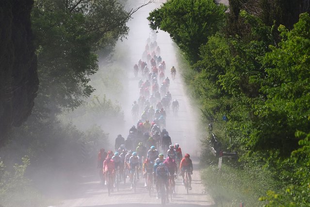 The pack rides on white roads of Tuscany during the 6th stage of the 107th Giro d'Italia cycling race, 180 km between Torre del lago Puccini and Rapolano Terme, on May 9, 2024. (Photo by Luca Bettini/AFP Photo)