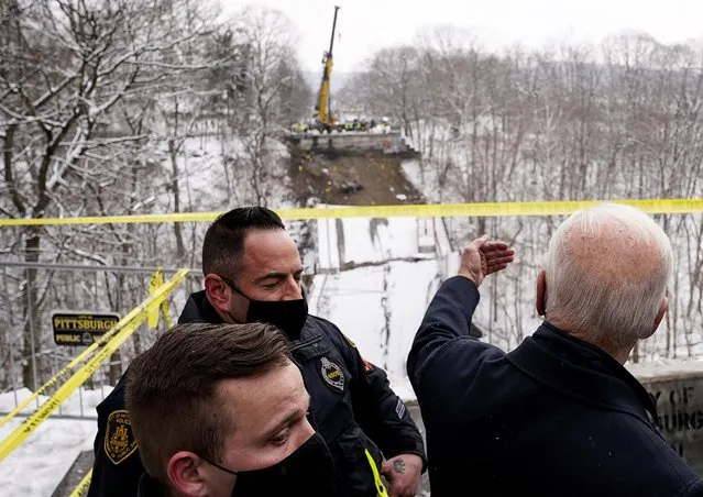U.S. President Joe Biden talks to first responders as he visits the site of a bridge collapse prior to Biden attending an earlier scheduled event in Pittsburgh, Pennsylvania, U.S., January 28, 2022. (Photo by Kevin Lamarque/Reuters)