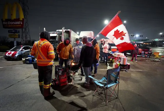 Truckers and supporters block the access leading from the Ambassador Bridge, linking Detroit and Windsor, as truckers and their supporters continue to protest against the COVID-19 vaccine mandates and restrictions in Windsor, Ontario, on Thursday, February 9, 2022. (Photo by Nathan Denette/The Canadian Press via AP Photo)