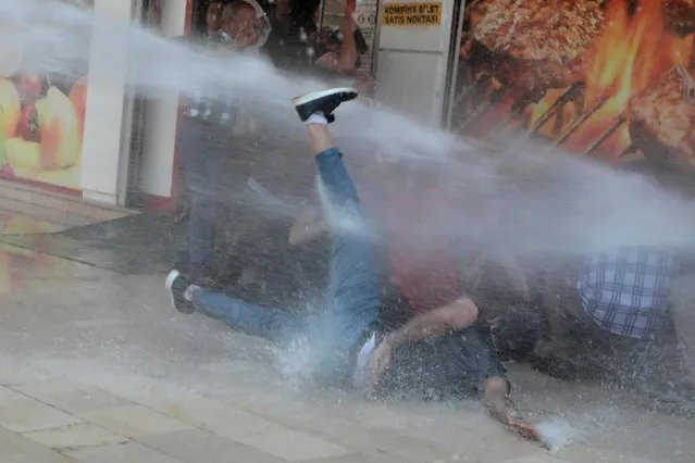 Turkish police use a water cannon to disperse demonstrators during a protest against the replacement of Kurdish mayors with state officials in three cities, in Diyarbakir, Turkey, August 19, 2019. Riot police fired water cannon and tear gas to disperse protesters demonstrating in southeast Turkey on Tuesday against the ousting of three Kurdish mayors five months after they were elected. (Photo by Sertac Kayar/Reuters)