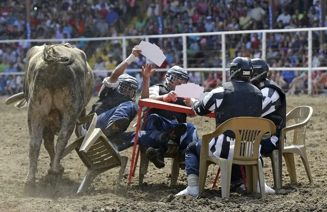 A bull rams inmates seated at a card table in the Convict Poker event at the Angola Prison Rodeo in Angola, La., Saturday, April 26, 2014. Those competing in the rodeo have to pass a physical to be deemed strong and healthy enough, and thousands of others work year-round making arts and crafts to sell at the event, according to the prison's athletic director. (Photo by Gerald Herbert/AP Photo)