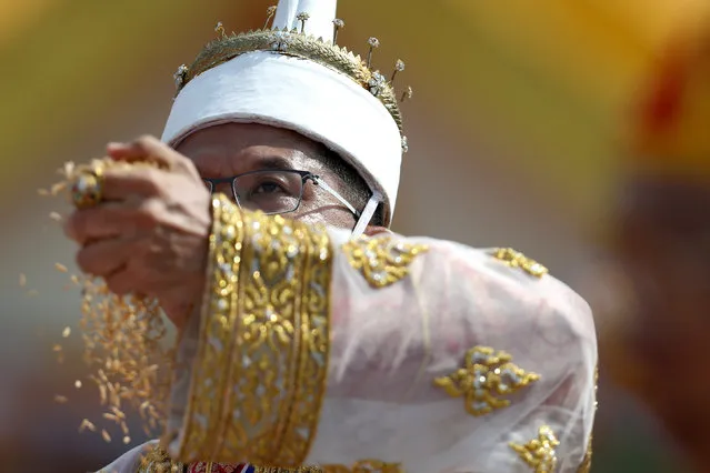 Theerapat prayurasiddhi, Permanent Secretary of the Thai Ministry of Agriculture and Cooperatives, dressed in a traditional costume, throws rice grains during the annual royal ploughing ceremony  in central Bangkok, Thailand, May 9, 2016. (Photo by Athit Perawongmetha/Reuters)