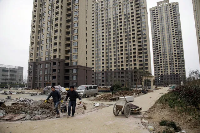 In this photo taken Friday, March 17, 2017, workers labor at a newly built condominium complex where a controversial mosque is planned in Hefei in central China's Anhui province. (Photo by Gerry Shih/AP Photo)