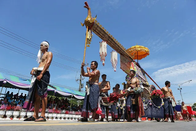Participants take part in a parade showcasing their home-made rocket during the Bun Bang Fai Rocket festival on May 10, 2014 in Yasothon, Thailand. The Bun Bang Fai Rocket festival is celebrated annually and culminates when home-made rockets are fired into the sky in a merit-making action that welcomes the beginning of the rainy season. (Photo by Taylor Weidman/Getty Images)