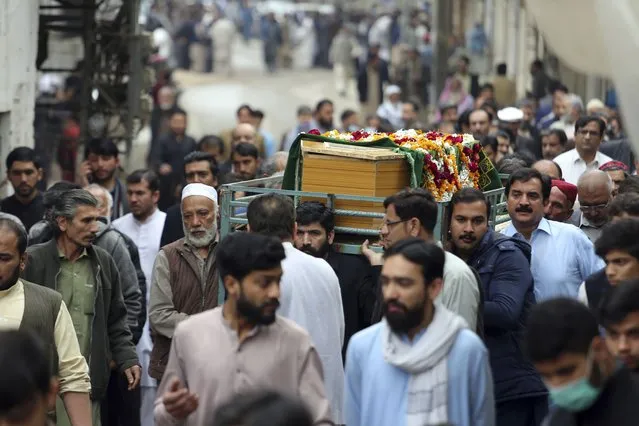 People carries the coffin of a victim of Friday's suicide bombing in Peshawar, Pakistan, Saturday, March 5, 2022. The Islamic State says a lone Afghan suicide bomber struck inside a Shiite Muslim mosque in Pakistan's northwestern city of Peshawar during Friday prayers, killing dozens worshippers and wounding more than 190 people. (Photo by Muhammas Sajjad/AP Photo)