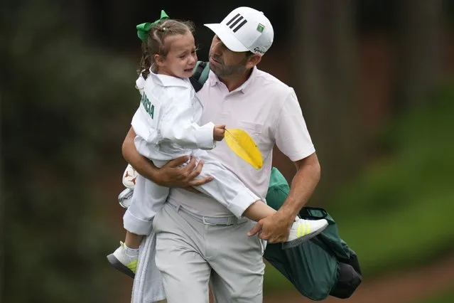 Sergio Garcia, of Spain, carries his crying daughter Azalea during the Par 3 contest at the Masters golf championship on Wednesday, April 6, 2022, in Augusta, Ga. (Photo by Jae C. Hong/AP Photo)