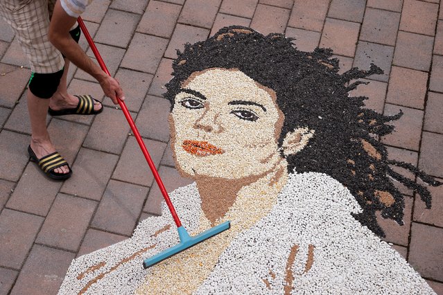 Kosovo artist Alkent Pozhegu works on a mosaic made of grains showing a portrait of Michael Jackson on the 15th anniversary of his death in Gjakova, Kosovo on June 25, 2024. (Photo by Valdrin Xhemaj/Reuters)