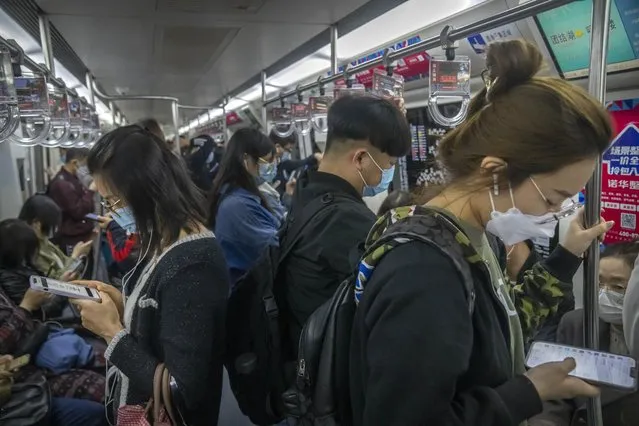 Commuters wearing face masks ride a subway train in Beijing, Tuesday, April 12, 2022. (Photo by Mark Schiefelbein/AP Photo)
