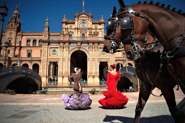 Woman wearing traditional Andalusian dresses stand on Plaza de Espana in Seville as Spain is bracing for an early heat wave on April 24, 2023. Drought-hit Spain is bracing for an early heat wave this week with temperatures forecast to hit 40 degrees Celsius (104 Fahrenheit) in some places, another sign of climate change. (Photo by Jorge Guerrero/AFP Photo)