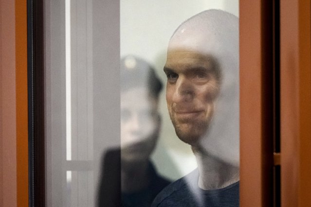 Wall Street Journal reporter Evan Gershkovich stands listening to the verdict in a glass cage of a courtroom inside the building of “Palace of justice”, in Yekaterinburg, Russia, on Friday, July 19, 2024. A Russian court convicted Gershkovich on espionage charges that his employer and the U.S. have rejected as fabricated. He was sentenced to 16 years in prison after a secretive and rapid trial in the country's highly politicized legal system. (Photo by Dmitri Lovetsky/AP Photo)