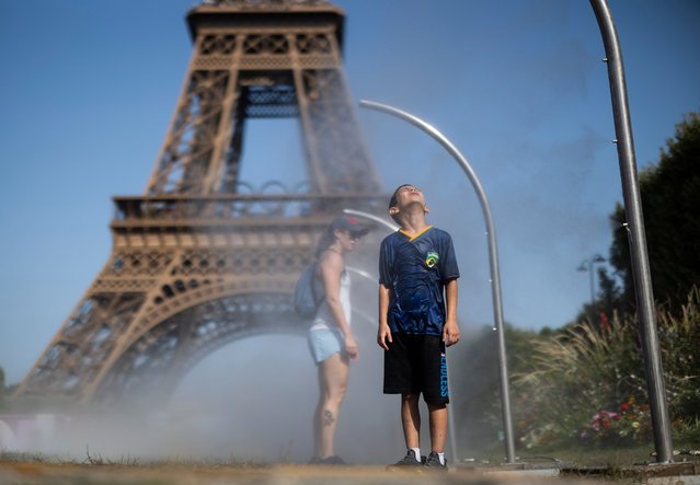 A young Brazilian fan cools off in front of the Eiffel Tower on day four of the Olympic Games Paris 2024 at on July 30, 2024 in Paris, France. (Photo by Ryan Pierse/Getty Images)