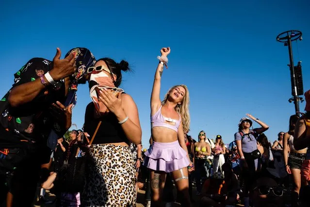 A woman dances to a performer at the Coachella Valley Music and Arts Festival held at the Empire Polo Club in Indio, California, U.S., April 24, 2022. (Photo by Maria Alejandra Cardona/Reuters)