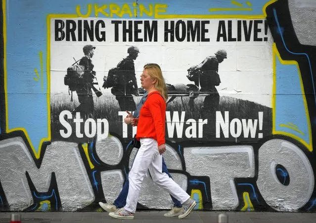 People pass by an anti-war poster in Kyiv, Ukraine, Saturday, May 14, 2022. (Photo by Efrem Lukatsky/AP Photo)