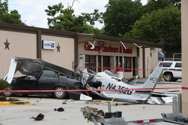 A small plane that crashed into a car in a parking lot near a Houston airport is roped off on Thursday, June 9, 2016. The  aircraft had been trying to land at Hobby Airport, in the southeastern part of the city,  when it crashed less than a mile northwest of the airport, said Lynn Lunsford, a spokesman for the Federal Aviation Administration. (Photo by Steve Gonzales/Houston Chronicle via AP Photo)