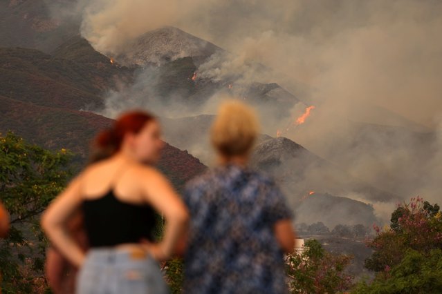 People look on, as the Airport Fire burns in the hills of Orange County, California on September 9, 2024. (Photo by Mike Blake/Reuters)