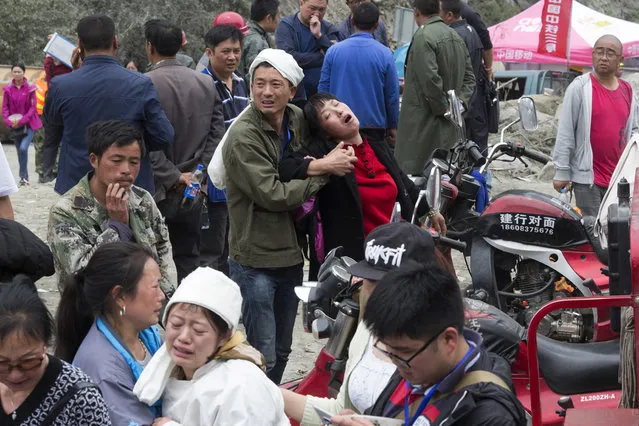 Relatives grief near bodies at the site of a landslide in Xinmo village in Maoxian County in southwestern China's Sichuan Province, Sunday, June 25, 2017. (Photo by Ng Han Guan/AP Photo)
