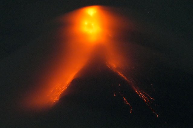 Mayon volcano belches red-hot emissions down it's slope as seen from Legaspi, Albay province, northeastern Philippines, Sunday, June 11, 2023. Albay was placed under a state of calamity last week to allow more rapid disbursement of emergency funds in case a major eruption unfolds. (Photo by Aaron Favila/AP Photo)