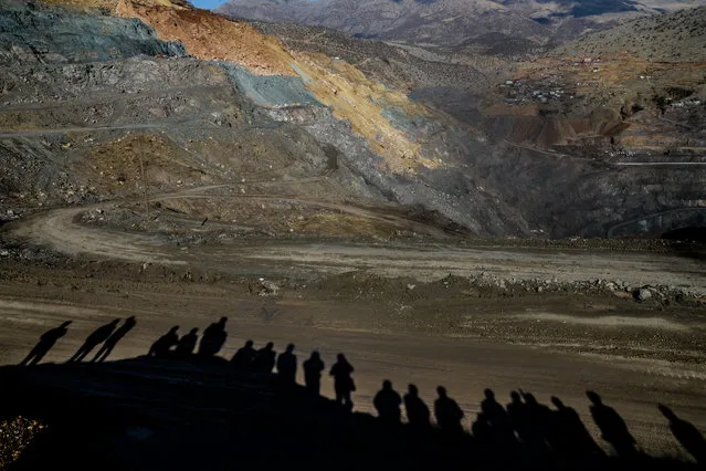 The shadows of relatives of miners are cast on the ground as they wait, while rescue workers search for trapped miners on November 18, 2016 at the accident site in the southeastern Siirt province. Turkish rescue workers were on  November 18 battling to save 13 miners trapped after the collapse of a copper mine already confirmed to have left at least three dead. (Photo by Ilyas Akengin/AFP Photo)