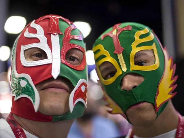 David Urias, 42, and his son Frank Urias, 14, both from Tucson, Arizona, poses for a photograph wearing Mexican wrestling masks on the opening day of Comic-Con 2014 in San Diego, California, USA, 24 July 2014. (Photo by David Maung/EPA)