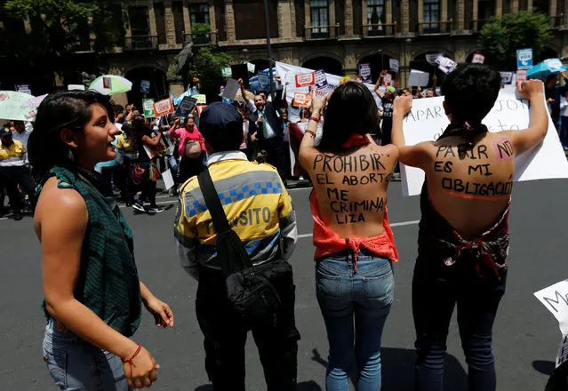 A group of pro-abortion rights activists gesture in front of people and pro-life activists during an anti-abortion demonstration outside the Supreme Court of Justice in downtown Mexico City, Mexico June 29, 2016. On the activist's back (C) reads: “Prohibiting abortion makes me a Criminal”. (Photo by Henry Romero/Reuters)