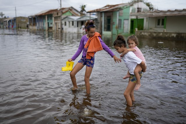 Children wade through a flooded street after the passing of Hurricane Rafael in Batabano, Cuba, Thursday, November 7, 2024. (Photo by Ramon Espinosa/AP Photo)
