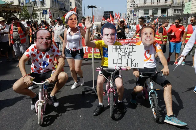 Protesters dressed like Tour de France cyclists ride children's bikes with left to right masks of Francois Hollande, French Job Minister Myriam El Khomri, French Prime Minister Manuel Valls, and French Economy Minister Emmanuel Macron, as they demonstrate in Marseille southern France, Tuesday, July 5, 2016. French unions are staging what is likely to be their last show of force against a labor bill that has divided the nation, as the lower house of Parliament takes up the bill for a second time. Placard refers to proposed labor reform law. (Photo by Claude Paris/AP Photo)