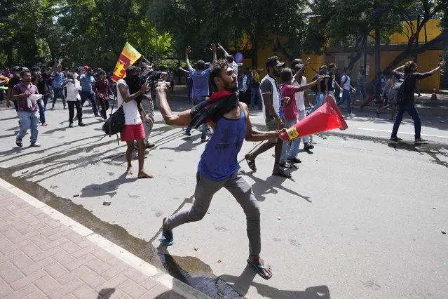 Protesters storm the compound of Sri Lankan Prime Minister Ranil Wickremesinghe's office, demanding he resign after president Gotabaya Rajapaksa fled the country amid economic crisis in Colombo, Sri Lanka, Wednesday, July 13, 2022. (Photo by Eranga Jayawardena/AP Photo)
