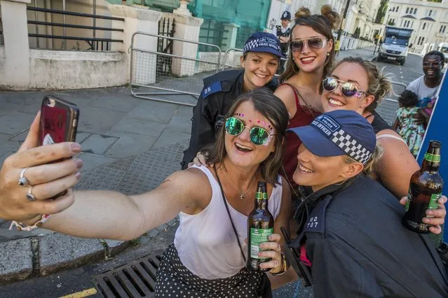 Riot police are on standby but some still have time for friendly interaction at Notting Hill Carnival 2017 on August 27, 2017 in London, England. Notting Hill Carnival the annual event on the streets of the Royal Borough of Kensington and Chelsea, over the August bank holiday weekend. It is led by members of the British West Indian community, and attracts around one million people annually, making it one of the world's largest street festivals. (Photo by Guy Bell/Rex Features/Shutterstock)