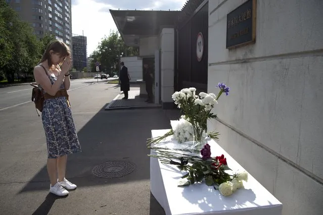 A woman reacts as she arrives to lay flowers in front of the entrance of the Japanese embassy in memory of the former Prime Minister Shinzo Abe, in Moscow, Friday, July 8, 2022. Abe was assassinated Friday on a street in western Japan by a gunman who opened fire on him from behind as he delivered a campaign speech – an attack that stunned the nation with some of the strictest gun control laws anywhere. (Photo by AP Photo/Stringer)