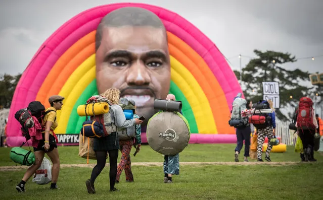 People pass a giant inflatable face of Kanye West as they arrive on the first day of the Bestival festival being held at the Lulworth Estate on September 7, 2017 in Dorset, England. Described as a boutique festival, the event is one of the last in summer festival season and is often seen as the UK festival season finale. It was started in 2004 by DJ Rob da Bank, and this year has moved from its original home on the Isle of Wight, to the Lulworth Estate, which also hosts its family-friendly sister event, Camp Bestival. (Photo by Matt Cardy/Getty Images)