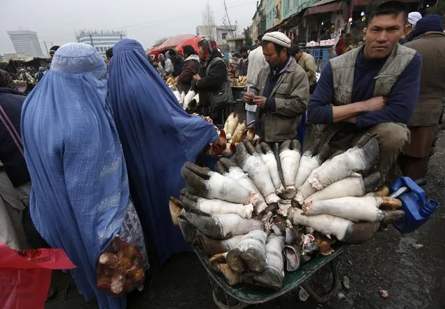 An Afghan butcher sells buffalo legs along a street in Kabul on January 12, 2015. (Photo by Omar Sobhani/Reuters)
