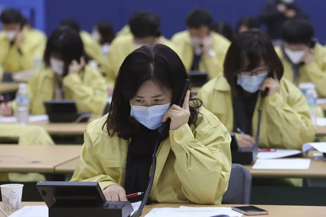 Government official wearing face masks make a phone call to the members of Shincheonji Church of Jesus to check if they have symptoms of suspected COBID-19 illness or not, at Goyang City Hall in Goyang, South Korea, Tuesday, March 3, 2020. The coronavirus spread to ever more countries and world capitals. (Photo by Ahn Young-joon/AP Photo)